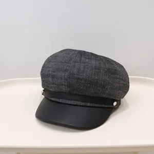 Close-up of a grey wool and black leather newsboy cap for women in winter.