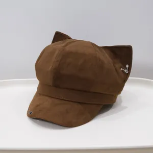 Macro view of brown suede newsboy cap featuring fox ears and metallic key charm detail