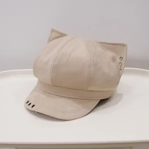 Detail view of a beige newsboy cap featuring cute cat ears and a small key charm.