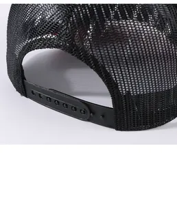 Macro detail showing the breathable black mesh and adjustable snapback of the trucker hat