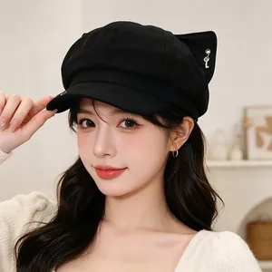 Detail shot of a black newsboy cap featuring cute fox ears and a small silver key charm.
