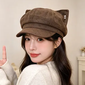 Close-up of a brown polka dot newsboy cap with cat ears on an Asian model.