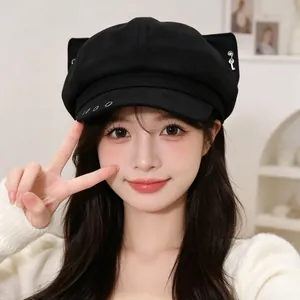 Close-up of black newsboy hat with cute ears and metal ring details
