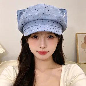 Light blue retro polka dot newsboy cap worn by a model for a chic fashion look