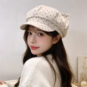 Stylish retro polka dot newsboy cap in cream with cat ear detail on female model