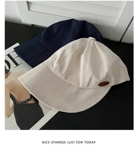 Vue détaillée de casquettes de baseball beige et bleu marine en tissu texturé sur fond noir