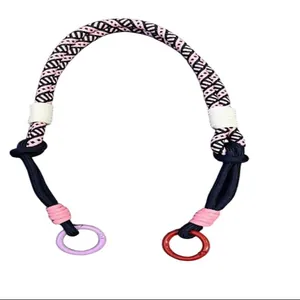 Close-up view of durable pink and black braided crossbody rope with metal rings.