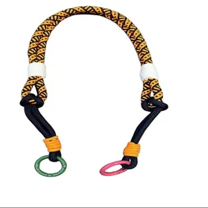 Macro detail of a colorful woven adjustable crossbody phone lanyard with pink and green rings