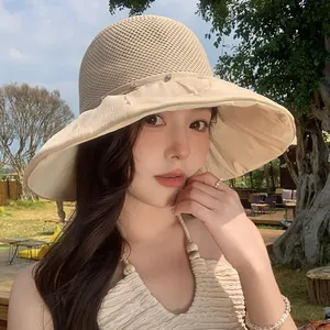Close-up of a beige breathable mesh sun hat with rhinestone details worn by an Asian model.