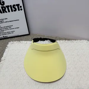 Minimalistischer gelber Sonnenhut mit verstellbarem Riemen auf strukturiertem Teppich