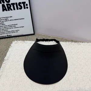 Detailansicht eines minimalistischen schwarzen Sonnenvisiers mit breiter Krempe auf Matte.