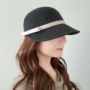 Elegante cappello da equitazione in paglia nera con fiocco crema per la protezione solare.