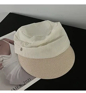 Elegant detail showing the pleated fabric crown and woven straw brim of this sun hat