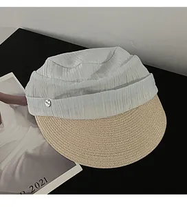 Close-up detail of pleated fabric crown and woven straw brim of equestrian hat