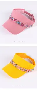 Due eleganti cappelli con visiera in rosa e giallo, con catene decorative in acrilico e strass.