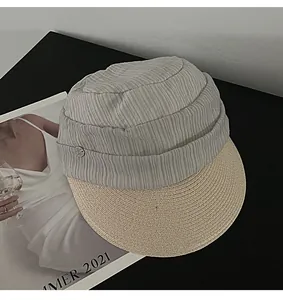 Close-up showing texture of grey pleated fabric and woven straw brim on summer hat