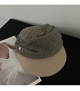 Detailed view of the olive pleated fabric crown and woven straw brim on this sun hat