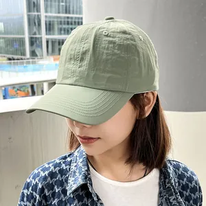 Close-up of a woman wearing a light green quick-dry soft top baseball cap outdoors