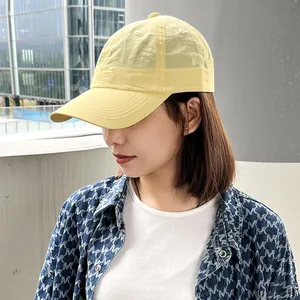 Close-up detail of an Asian woman wearing a yellow quick-dry running baseball cap