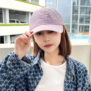 Close-up of a lavender quick-dry baseball cap worn by a model in outdoor lighting
