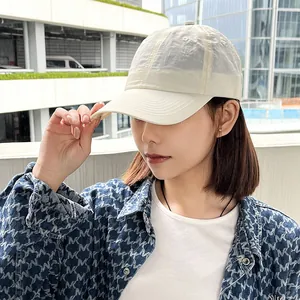 Close-up view of a woman wearing an off-white quick-dry sports baseball cap outdoors