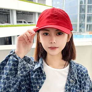 Asian woman wearing a red quick-dry sports baseball cap for outdoor sun protection