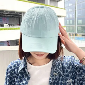 Detailed close-up view of a light blue quick-dry baseball cap worn by a female model outdoors.