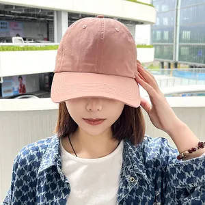 Close-up of woman wearing a pink quick-dry baseball cap in a casual outdoor setting