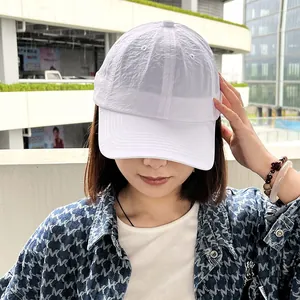 Detail view of a white quick-dry baseball cap on a model for outdoor sports and sun protection