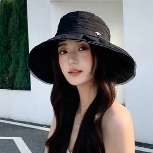 Fashionable pleated black bucket hat with wide brim for elegant outdoor sun protection.