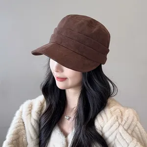 Detailed view of a brown pleated suede newsboy equestrian hat worn by an Asian model