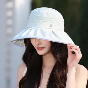 Close-up of elegant pleated light blue sun hat worn by a model in outdoor setting
