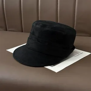 Detailed view of black pleated suede newsboy cap featuring a classic flat top design