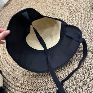 Detailed inside view of women's straw sun hat with adjustable black tie straps