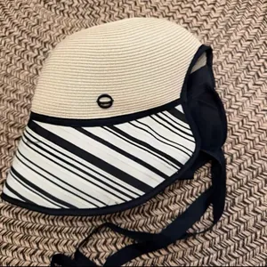 Close-up of a woven sun hat with a striped brim and black ribbon tie for women