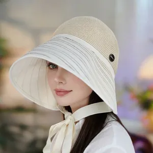 Elegant women's summer sun bucket hat featuring a large brim and stylish chin strap