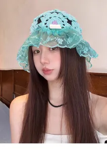 Detailed view of hand-knitted crochet hat featuring elegant lace trim and floral patterns