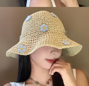 Primo piano di donna con cappello di paglia decorato con fiori all'uncinetto per mare