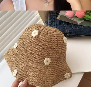 Primo piano di un cappello di paglia da spiaggia con piccole decorazioni a margherita