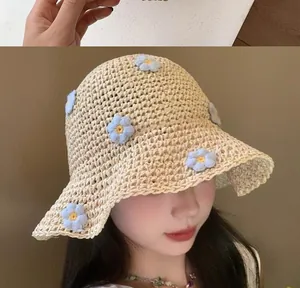 Dettaglio di un cappello da sole in paglia intrecciato a mano con fiori all'uncinetto