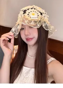 Close-up of hand-knitted crochet beanie with delicate lace trim and daisy pattern