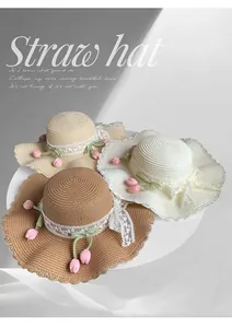 Close-up of sun hats with lace bows and pink tulip decorations in various colors
