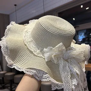 Vista dettagliata del cappello di paglia a testa piatta da donna con un fiocco in pizzo