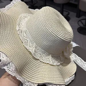 Dettaglio di un cappello di paglia a testa piatta con eleganti bordi in pizzo bianco