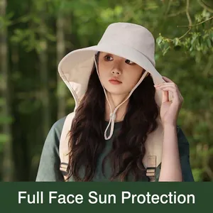 Close-up view of a beige wide brim sun hat with neck protection flap worn outdoors