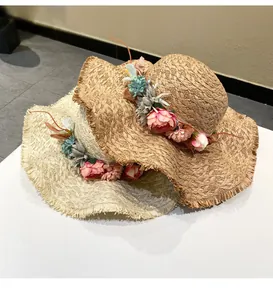 Detailed view of hand-woven raffia straw hats featuring elegant floral wreath accents.