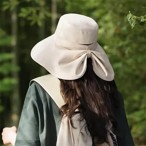 Wide brim sun hat with neck protection and bow detail for summer UV protection.