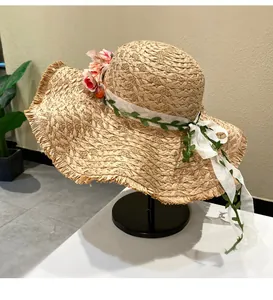 Handwoven wide-brim raffia straw hat with floral wreath for summer beach vacation sun protection