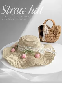 Close-up of elegant straw sun hat featuring delicate lace trim and pink tulip floral accents