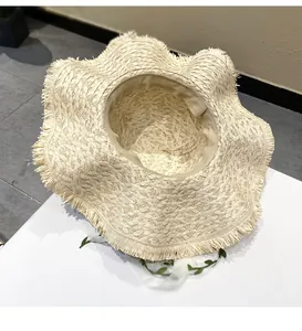 Detailed view of the interior and hand-woven texture of a wide-brimmed raffia beach hat